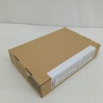 箱を斜め上から写したもの。茶色い上面と側面の白いラベルの端