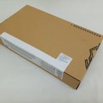 外箱を斜め上から撮った写真。上面と白い帯の面が写っています。