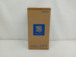 茶色の輸送箱の正面。青い「メガトレショップ」のロゴがあります。