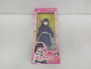 外箱の正面。ピンク色の箱の窓の中に、紫色の隊服を着た人形が入っています。