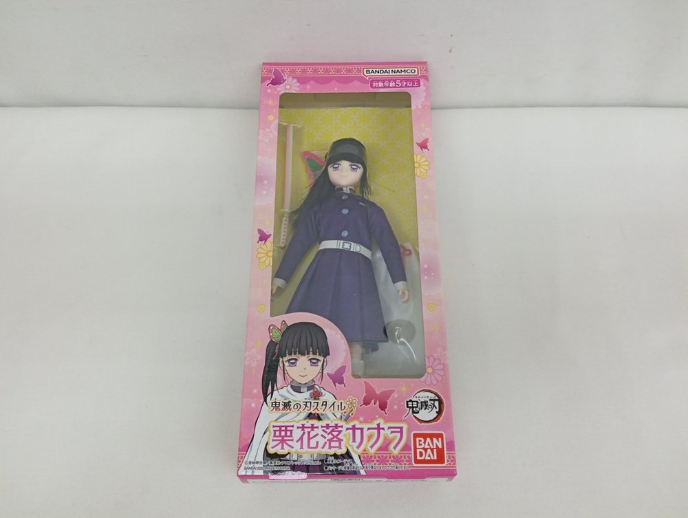外箱の正面。ピンク色の箱の窓の中に、紫色の隊服を着た人形が入っています。