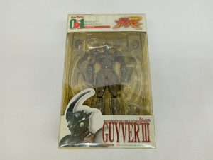 透明のプラスチックケースに入った本体を正面から写した写真。台紙に「GUYVER III」の表記があります。