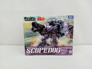 外箱の正面。紫色のロボットの絵と「SCOPEDOG」「ATM-09-GGG」の文字、「ガガンガン」「ボトムズ」のロゴが印刷されています。
