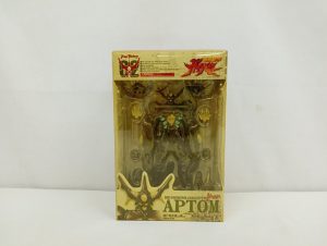 黄色く変色したプラスチックの箱の正面。中に本体とパーツ、下に「BIO FIGHTER COLLECTION APTOM FULL BLAST」の印字。