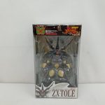 透明のプラスチック箱の正面。中に濃い茶色のフィギュアが収まり、下に「ZX・TOLE」の表示があります。