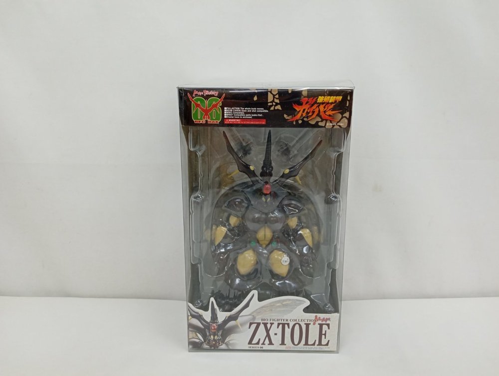 透明のプラスチック箱の正面。中に濃い茶色のフィギュアが収まり、下に「ZX・TOLE」の表示があります。