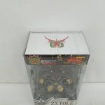 パッケージを斜め上から。天面の紋章のマークと、中のフィギュアが写っています。
