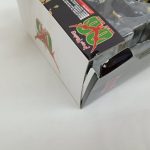 パッケージの角のアップ。天面の紋章のマークとプラスチック箱のふちが写っています。