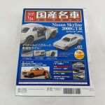 箱の裏面。車の写真、記事の見出し、注意書きとバーコードが印刷されています。