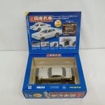 箱を開けた状態を斜めから。中に白いミニカーが収まっています。