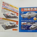 冊子と箱を並べた様子。冊子には車の写真と記事が印刷されています。