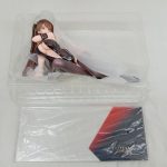 ブリスターに入ったフィギュアと、赤と黒の模様の台座