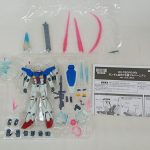 本体、ビームサーベル、エフェクトパーツ、交換用の手と説明書を並べた様子