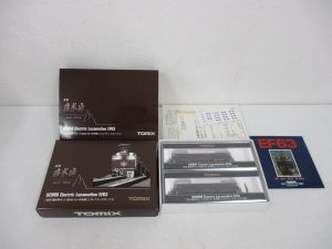 外箱とスリーブ、2両入りのケース、説明書と冊子を並べた全体。