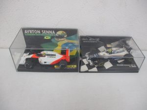 ケースに入った2台を並べた写真。左の白と赤の車が本商品の McLaren Honda V12 1991 です。