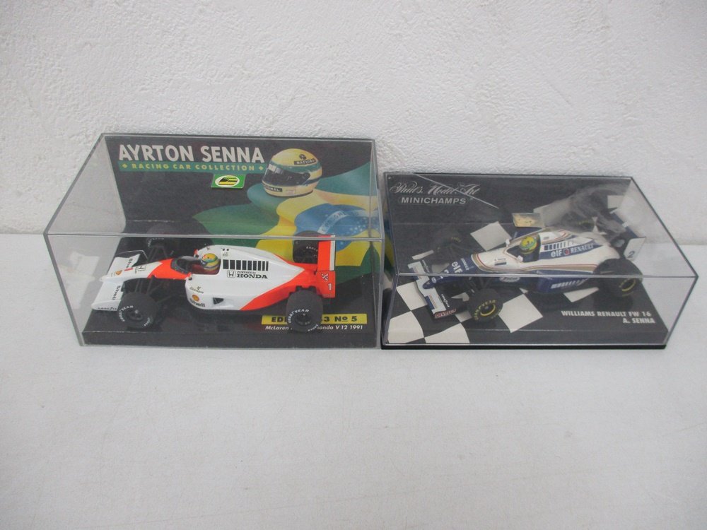 ケースに入った2台を並べた写真。左の白と赤の車が本商品の McLaren Honda V12 1991 です。