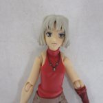 上半身のアップ。銀髪のショートヘアと赤いトップスです。