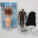台紙に入った本商品と、横に並べた別の人形。台紙には BERSERK ベルセルク の印字があります。