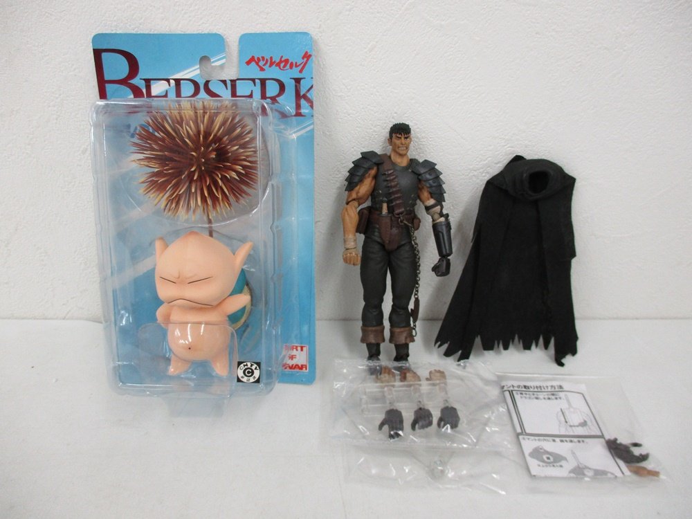 台紙に入った本商品と、横に並べた別の人形。台紙には BERSERK ベルセルク の印字があります。