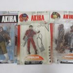 3つの台紙を並べた写真。中央の赤いジャケットの人形が本商品の 金田 です。