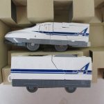 箱の中の2両の車両。N700A のロゴが入った白い車体です。
