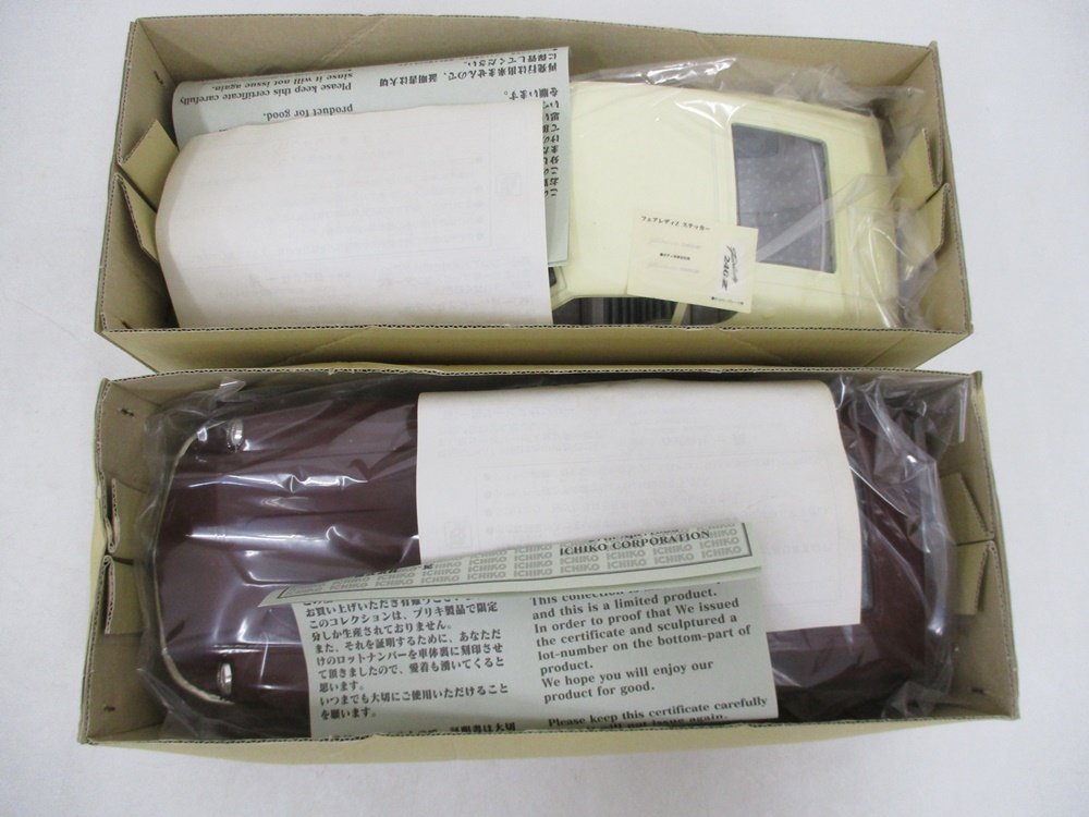 箱に収まった2台。下が本商品の暗い赤の車です。