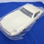 袋に入った白い本体を斜め前から撮影。