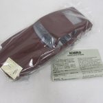 袋に入った暗い赤の本体と証明書。