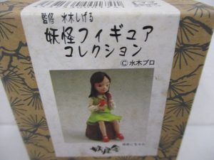 外箱正面の拡大。切り株に座る女の子の写真があります。