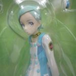 窓越しに撮影した本体の上半身。水色の髪と白い服の造形です。