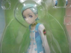窓越しに撮影した本体の上半身。水色の髪と白い服の造形です。