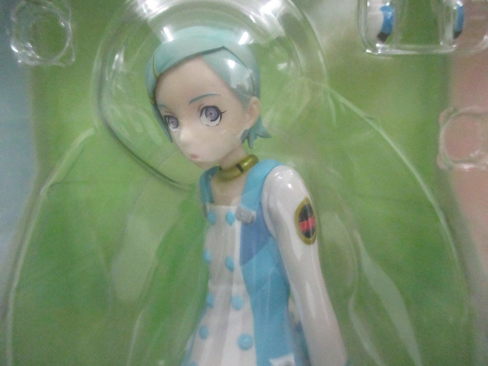 窓越しに撮影した本体の上半身。水色の髪と白い服の造形です。