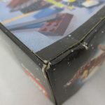 外箱の角の拡大。茶色の小舟の写真の面に傷みがあります。