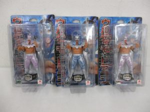 3枚の台紙を並べた正面。左と右の紫のラメの人形2個が本商品です。