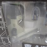 窓越しに撮影した AT-FLY の機体とパイロットのフィギュア。箱に値札シールが貼られています。