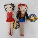 2体を並べた正面。左が赤いドレス、右が黒い上着と青いスカートの布製人形です。