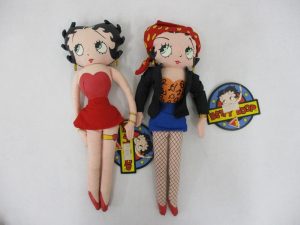 2体を並べた正面。左が赤いドレス、右が黒い上着と青いスカートの布製人形です。