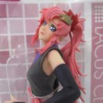 箱越しに撮影した本体の上半身。長いピンクの髪と黒い服の造形です。