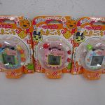 同じ出品の3点を並べた正面。中央のピンクが本商品です。台紙に たまごっち プラス チョイがえ の印字があります。