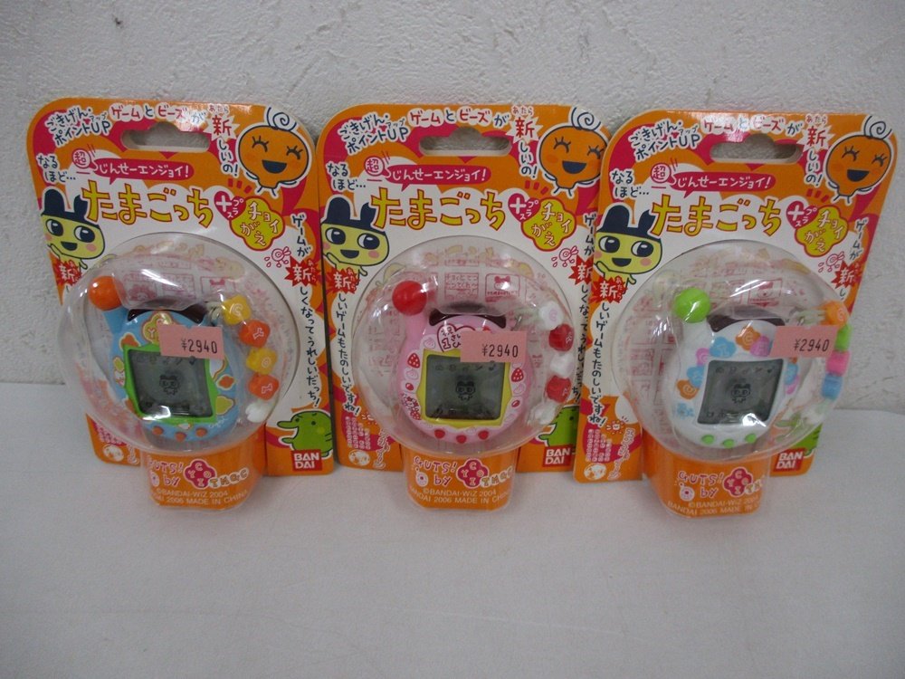 同じ出品の3点を並べた正面。中央のピンクが本商品です。台紙に たまごっち プラス チョイがえ の印字があります。