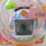 ブリスター越しに撮影した白い本体とビーズ。値札シールが貼られています。