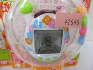 ブリスター越しに撮影した白い本体とビーズ。値札シールが貼られています。