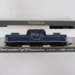 ケースに入った機関車。2215 J.R. Diesel Locomotive Type DD51 と JR北海道色 の印字があります。