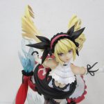 顔と上半身のアップ。金髪で黒いリボンを付けています。