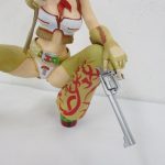 片膝を立てた脚とリボルバーのアップです。