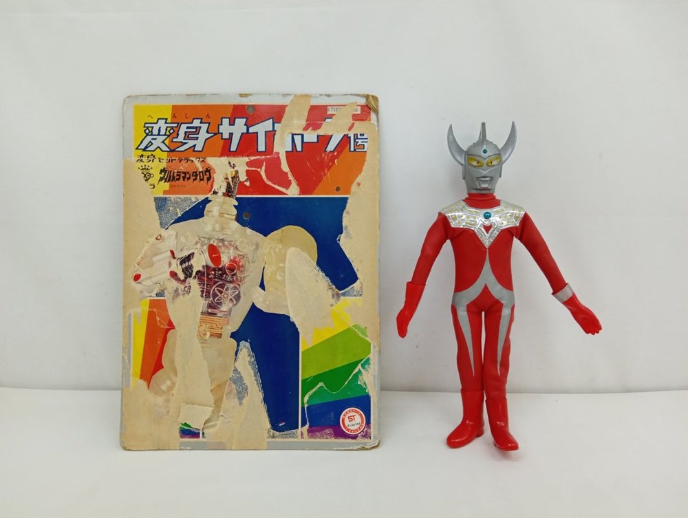 変身セットの台紙と、ウルトラマンタロウのコスチュームを着せた人形