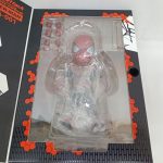 窓越しに写したブリスター内のフィギュアと付属パーツ