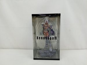 透明の外箱の正面。Xenosaga IIIのロゴと中のT-elosのフィギュア