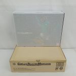 輸送箱の上に置いた、保護シートに包まれた商品箱