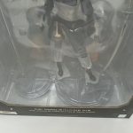 窓越しのフィギュアの足元と台座